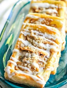 cinnamon rolls on a plate with icing drizzled over them, ready to be eaten