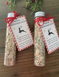 two bottles filled with sprinkles on top of a wooden table next to a christmas tree