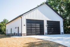 two garages are shown in front of a white building with black doors and windows