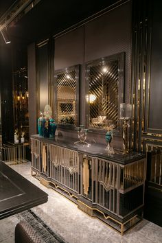 an elegantly decorated dining room with gold accents and glassware on the sideboard