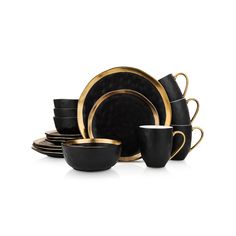 black and gold dinnerware set with cups, saucers and spoons on a white background