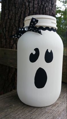 a painted mason jar with a black and white face drawn on it's lid