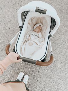 a baby in a stroller being held by someone's hand