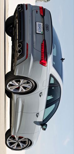 the rear end of a white car with its door open