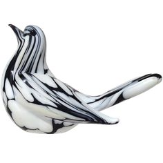 a black and white glass bird sitting on top of a table next to a wall