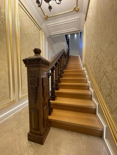 the stairs are made of wood and have intricate carvings on them, along with a chandelier