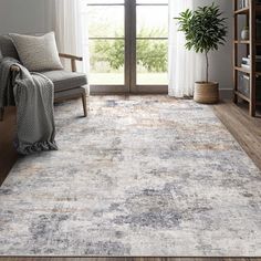 a living room with a large rug on the floor and a chair in front of it