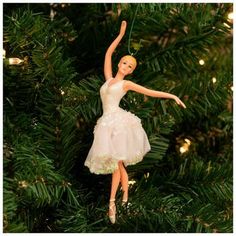 a ballerina ornament hanging from a christmas tree