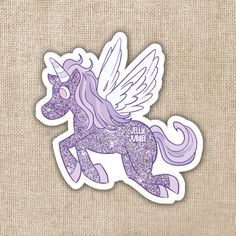 a purple sticker with an image of a unicorn on it's back and wings