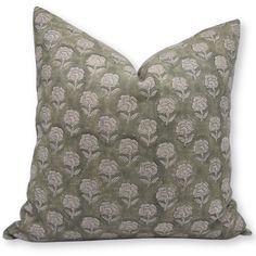 a green pillow with white flowers on the front and back, against a white background