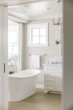 a white bath tub sitting in a bathroom next to a window