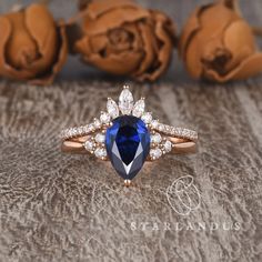 an engagement ring with a pear shaped blue sapphire surrounded by diamonds