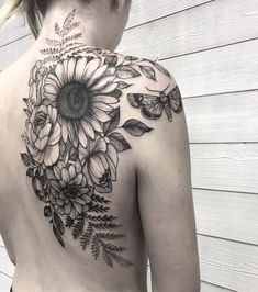 a woman's back with flowers and butterflies on it