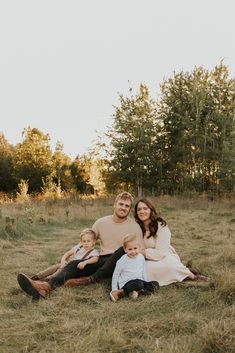 a family sitting on the grass in an open field