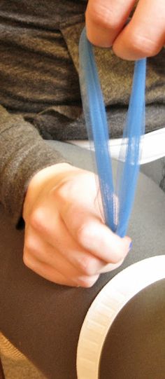 a person holding a blue object in their hand while sitting at a table with plates on it