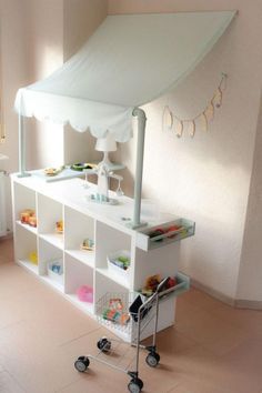 a baby changing table in the corner of a room with a canopy over it's top