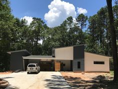 a truck is parked in front of a house with two garages on each side