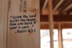 a piece of wood with writing on it in the middle of a wooden structure that is under construction