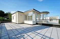 a small white house sitting on top of a wooden deck