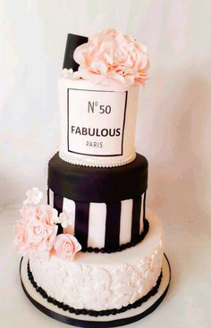 a three tiered cake with black and white stripes and flowers on the bottom layer