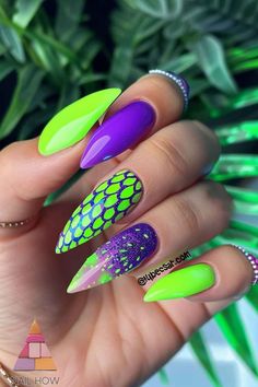 Dive into the deep end of neon nail art with these mermaid-inspired designs! The combination of neon green, purple, and glittery scales makes these nails a unique and eye-catching choice. Check out nailhow.com for more neon nail designs acrylic and summer nails ideas. Purple And Lime Green Nails, Neon Green And Purple Nails Design, Neon Green Halloween Nails, Purple Green Nails, Purple Green Nails Halloween, Lime Green Halloween Nails, Purple And Green Nails, Scale Nails, Nail Designs Acrylic