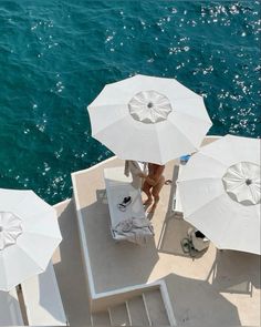 several white umbrellas are set up on the side of a boat in the water