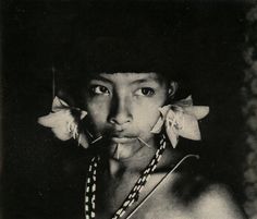 an old photo of a young man with flowers in his hair and necklaces around his neck