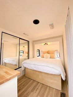 a bedroom with two beds and mirrors in it