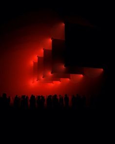 a group of people standing under red lights