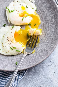 two fried eggs on a plate with a fork