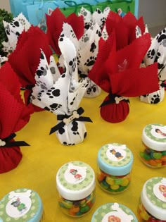 a table topped with lots of cupcakes covered in frosting next to candy