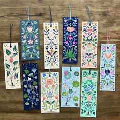 six handmade cards with flowers and leaves on them, hanging from clothes pegs