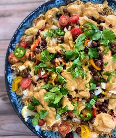 a blue bowl filled with rice, beans and veggies on top of a wooden table