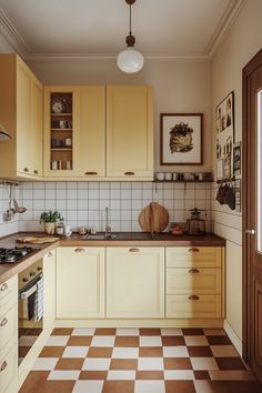 a kitchen with yellow cabinets and checkered flooring on the floor, along with an oven