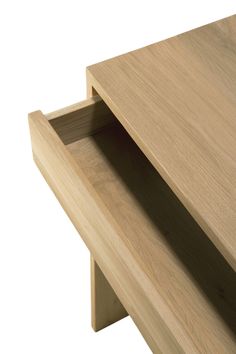 an open drawer on the side of a wooden table