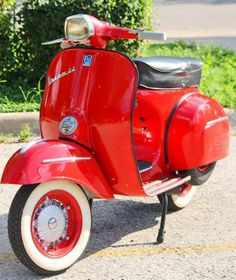 a red scooter is parked on the street