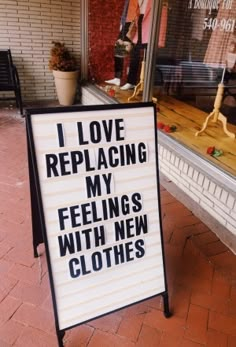 a sign in front of a store that says i love replacing my feelings with new clothes