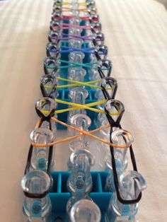 a row of glasses sitting on top of a bed covered in plastic cups and wires