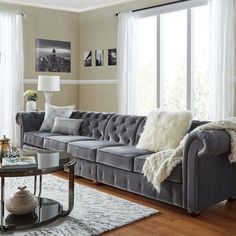 a living room filled with furniture and lots of windows