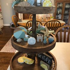 a three tiered tray with various items on it in a kitchen area next to a dining room table