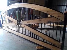 a large wooden gate with metal bars on the top and bottom, in an industrial building