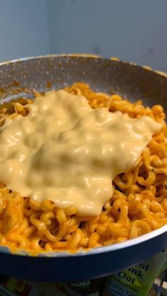 macaroni and cheese is being stirred in a skillet on the stove top