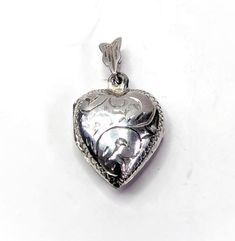 Find a heart shape locket with an engraved design on the front and the back.  Markings: no markings tests as silver Size: 1.6 cm x 1.3cm excluding the bale Weight: 2.1 grams Condition: The locket is in good condition, its is opening and closing well. SFind more unique lockets in my shop. https://www.etsy.com/uk/shop/perdisjewellerybox?ref=simple-shop-header-name&listing_id=1217630409&search_query=locket&sort_order=relevance Engraved Open Heart Locket Necklace In White Gold, Engraved Open Heart White Gold Locket Necklace, Double Heart Locket Necklace In White Gold, Double Heart White Gold Locket Necklace, White Gold Double Heart Locket Necklace, Silver Engraved Open Heart Locket Necklace, Engraved Double Heart Locket Necklace In White Gold, Antique Silver Heart Locket Necklace, Silver Heart Charm Locket Necklace