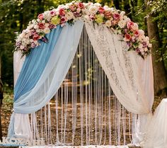 an outdoor wedding ceremony set up with blue drapes and flowers