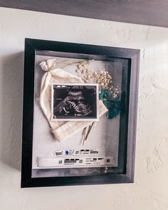 a framed photograph of a baby's diaper and flowers