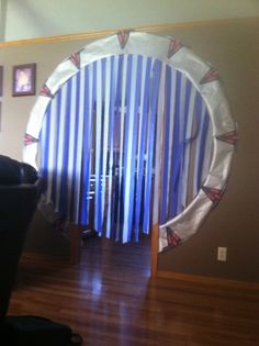 a living room with a chair and a large round mirror in the middle of it