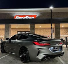 a grey sports car parked in front of a store at night with the name ranetta on it