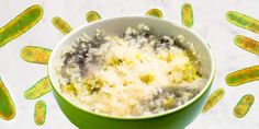 a green bowl filled with food on top of a white countertop next to germs