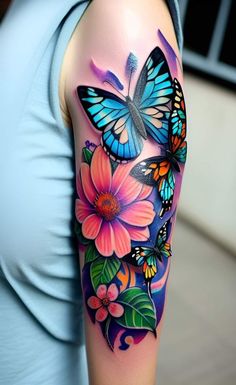 a woman's arm with colorful butterflies and flowers on the arm, while she is wearing