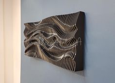 a metal art piece mounted to the side of a wall next to a blue wall